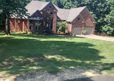 APEX Lawn Care service showcasing a well-maintained residential lawn in Little Rock, Arkansas, featuring a brick home and manicured grass area.