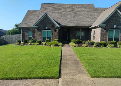 Well-maintained lawn and landscaped front yard of a brick home in Central Arkansas, showcasing APEX Lawn Care's professional lawn care services.
