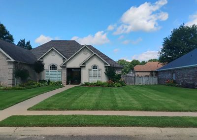 Lawn care service example showcasing a well-maintained lawn and landscaped home exterior in Central Arkansas.