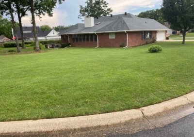 A single-story brick house with a screened porch and well-maintained lawn on a cloudy day. - Little Rock Lawn Care and Mowing Services by Apex Lawn Care (Note: The original sentence does not contain the word person to replace it with employee.) - Little Rock Lawn Care and Mowing Services by Apex Lawn Care