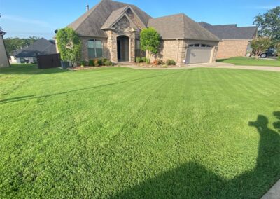Well-manicured lawn in front of suburban house on a sunny day. - Little Rock Lawn Care and Mowing Services by Apex Lawn Care