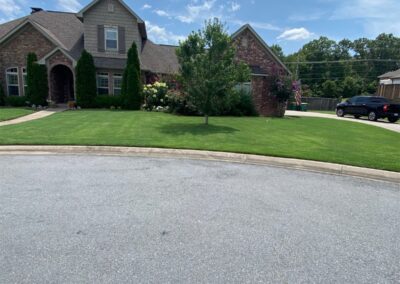 A suburban house with a well-maintained lawn under a clear sky. - Little Rock Lawn Care and Mowing Services by Apex Lawn Care