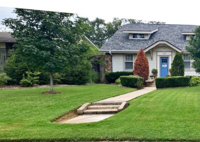 A quaint Little Rock Metro Area house with a well-manicured lawn and a stone pathway leading to the employee's front door. - Little Rock Lawn Care and Mowing Services by Apex Lawn Care