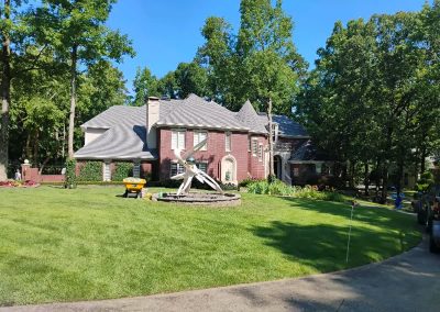 Lawn care service showcasing a well-maintained residential property in Central Arkansas, featuring lush green grass and landscaped garden with decorative elements.