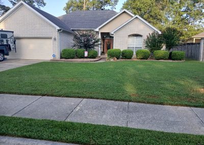 Well-maintained lawn and landscaped front yard of a residential property in Central Arkansas, showcasing APEX Lawn Care services.